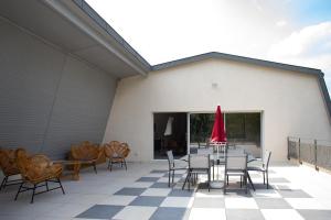 a patio with a table and chairs and a red umbrella at Champagne André Bergère - Guest House in Épernay