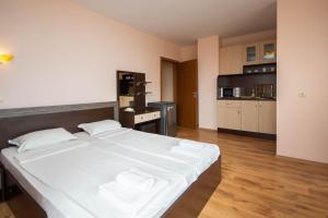 una camera con un grande letto bianco e una cucina di Villa Tuna a Sveti Vlas