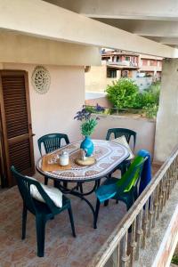 un patio con tavolo e sedie sul balcone. di Giaco's Apartments 2 a Villasimius