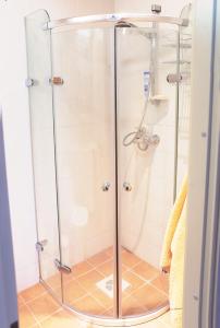 um chuveiro com uma porta de vidro na casa de banho em Kalevite Kodu 2-toaline apartment! em Kuressaare