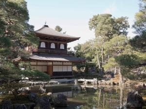 a building with a pond in front of a garden at Guest House Aoi Nakamoto in Kyoto