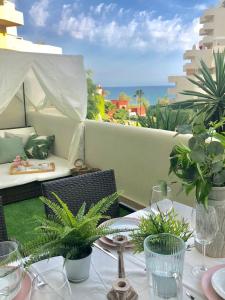 una mesa con sillas y una mesa con plantas en el balcón en Premium Apartment in Benalbeach, Benalmadena, en Benalmádena