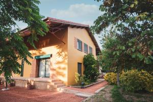 een geel huis met een raam en bomen bij Hotel La Parada del Compte in Torre del Compte