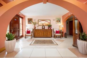 an archway leads into a living room with pink chairs at Willa u Wójta in Pobierowo +61 photos