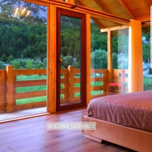 1 dormitorio con 1 cama y puertas correderas de cristal en Villas Jezerca en Valbonë