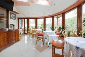 a dining room with tables and chairs and windows at Willa u Wójta in Pobierowo