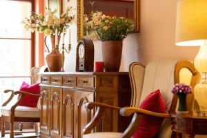 a room with chairs and a dresser with flowers on it at Willa u Wójta in Pobierowo