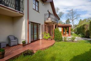 a house with a deck and a balcony on a yard at Willa u Wójta in Pobierowo