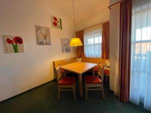 een eetkamer met een tafel en stoelen en een raam bij Appartement zum Hirsch'n in Waldkirchen