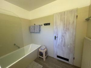 een badkamer met een bad en een douche met een kruk bij Appartement zum Hirsch'n in Waldkirchen