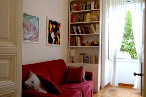 a living room with a red couch and a book shelf at Il Limone A San Pietro in Rome