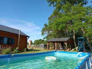 a swimming pool with a gazebo and a playground at Smocze Ranczo in Ośno Lubuskie