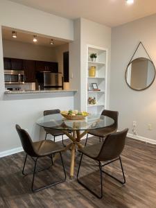 a dining room with a glass table and chairs at Newly Furnished 1BR Apartment w/ Hermann Park View in Houston