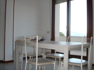 a dining room with a white table and chairs at Appartamento San Benedetto in Desenzano del Garda