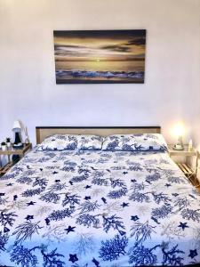 een slaapkamer met een bed met een blauwe en witte sprei bij Casa Vacanza Grisolia Lido in Grisolia