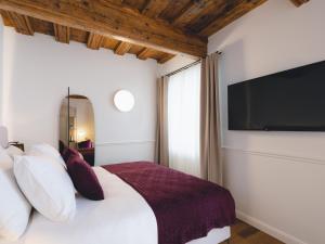 a bedroom with a bed with a large television on the wall at Hotel Heritage in Ljubljana