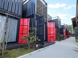 a row of red doors on the side of a building at HOTEL R9 Kujukuri "ex Casual Resort COFF Ichinomiya" in Ichinomiya
