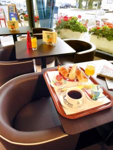 ein Tablett mit einer Tasse Kaffee und Brot in der Unterkunft Hotel les Pecheurs in Lorient