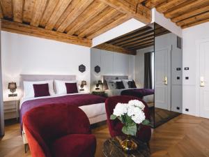 a bedroom with two beds and a table with flowers at Hotel Heritage in Ljubljana