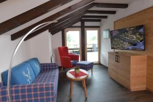 a living room with a blue couch and a red chair at Ferienwohnungen Brigitte in Oberstdorf