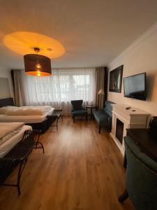 a living room with two beds and a fireplace at Hotel Niedersachsen in Quakenbrück