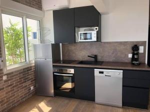 une cuisine avec un réfrigérateur et un micro-ondes dans l'établissement NEW YORK, à La Grande Motte 14 autres photos