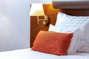 a bed with a pillow and a lamp on it at Hotel Kaj in Marija Bistrica