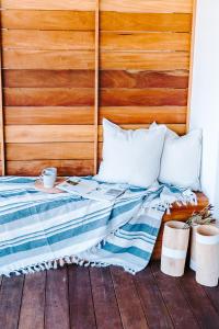 uma cama com cabeceira em madeira e almofadas brancas em Skoon Seaside Accommodation em Skoenmakerskop