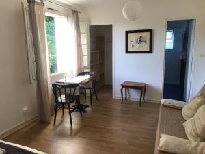 a living room with a table and chairs and a window at Une nuit sur Loire in Trèves-Cunault