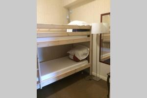 Zimmer mit 2 Etagenbetten und einem Spiegel in der Unterkunft Appartement spacieux 78m2 plein centre, balcon, jusqu’à 6 personnes in La Bourboule