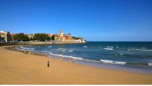 a group of people walking on the beach at Hotel Prada. in Gijón