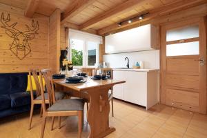 a kitchen and dining room with a wooden table and chairs at Family Vacation House with Garden & Parking by Renters in Zastań