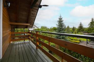 a wooden balcony with a view of the woods at Family Vacation House with Garden & Parking by Renters in Zastań