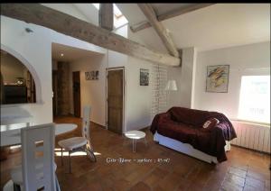 Le Poujol-sur-OrbにあるMaison Bersaneのベッドルーム1室(ベッド1台、テーブル、椅子付)