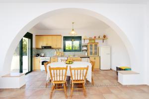 - une cuisine et une salle à manger avec une table et des chaises dans l'établissement Seaside Villa, à Gennadi