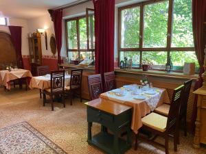 un comedor con mesas, sillas y ventanas en Kreuzerhof Hotel Garni, en Rothenburg ob der Tauber