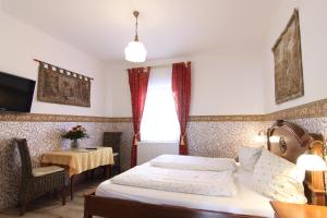 a bedroom with a bed and a table and a window at Kreuzerhof Hotel Garni in Rothenburg ob der Tauber