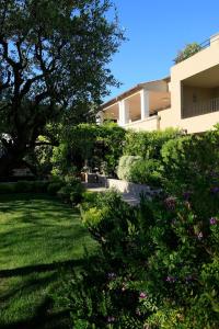 un cortile con un edificio e alcuni cespugli e fiori di Résidence Hôtelière 4 étoiles Les Mas du Grand Vallon a Mougins