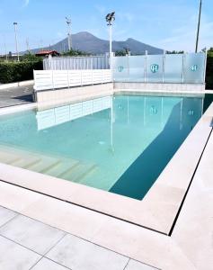 een zwembad met blauw water en een hek bij Villa Costantino in Pompei