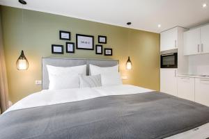 um quarto com uma cama grande e algumas fotografias na parede em Business Hotel Maier - kontaktloser Check-in em Götzis