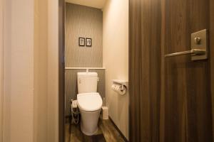 a bathroom with a white toilet in a room at HOTEL R9 Kujukuri "ex Casual Resort COFF Ichinomiya" in Ichinomiya
