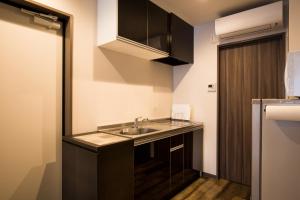 a small kitchen with a sink and a refrigerator at HOTEL R9 Kujukuri "ex Casual Resort COFF Ichinomiya" in Ichinomiya