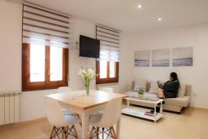 a woman sitting on a couch in a living room at Apartamento La Placeta in Monroyo