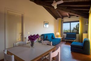 a living room with a table and blue chairs at Residence Bouganville in Porto Rotondo