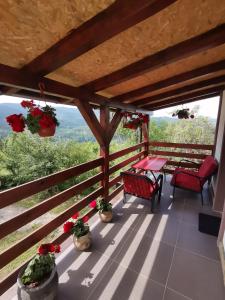 a balcony with a table and chairs and flowers at Tri bagrema KM in Mokra Gora
