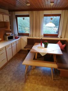 a kitchen with a table and a bench in a room at Landhaus Kohlstatt in Finkenberg