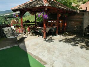 eine Terrasse mit einem Pavillon, einem Tisch und Stühlen in der Unterkunft Tri bagrema KM in Mokra Gora