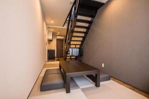 a hallway with a wooden table and a staircase at HOTEL R9 Kujukuri "ex Casual Resort COFF Ichinomiya" in Ichinomiya