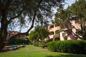 a large building in a park with trees and grass at Residence Bouganville in Porto Rotondo