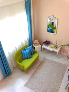 een woonkamer met een groene stoel en een spiegel bij Pepe's apartment in Siracusa